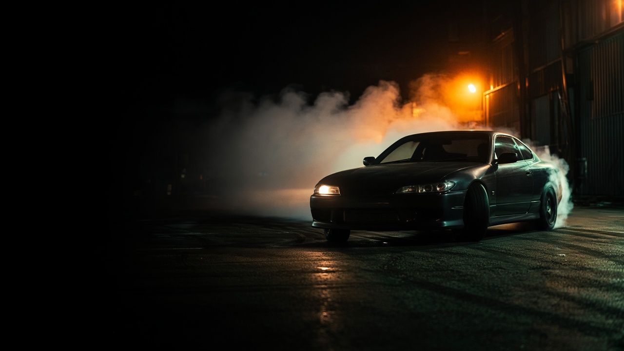 Drift car sliding at night through thick tyre smoke